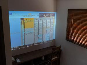 a large projection screen in a room with a desk at FLAG Zushi in Zushi