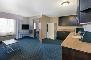 a room with a kitchen with a refrigerator and a table at Holiday Inn Express & Suites - Pharr, an IHG Hotel in Pharr