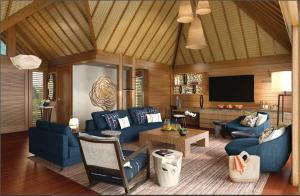 a living room with blue furniture and a flat screen tv at Four Seasons Resort Bora Bora in Bora Bora