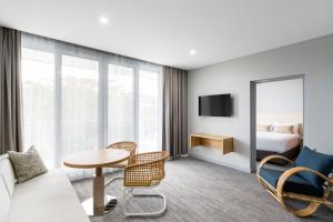 a hotel room with a bed and a table and chairs at Abode Malua Bay in Malua Bay