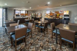 a restaurant with tables and chairs and a counter at Holiday Inn Express & Suites Santa Clara, an IHG Hotel in Santa Clara