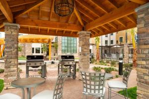 a patio with a grill and a table and chairs at Staybridge Suites - St George, an IHG Hotel in St. George