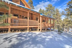 a log cabin with a porch in the snow at Log Cabin with Mountain Views about 30 Mi to Pikes Peak! in Florissant