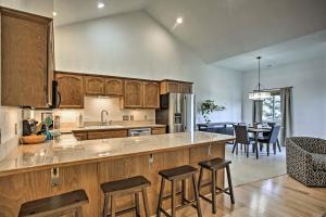 a kitchen with wooden cabinets and a table and chairs at Modern Coeur dAlene Getaway Condo Walk Downtown! in Coeur d'Alene