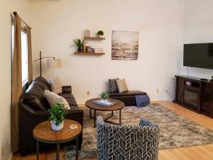 a living room with a couch and a tv at Modern Coeur dAlene Getaway Condo Walk Downtown! in Coeur d'Alene