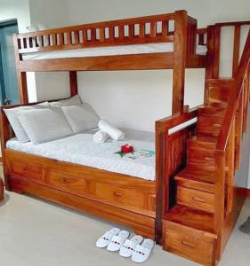 a wooden bunk bed with slippers on the floor at Adama Farmhouse @ Hacienda San Benito in San Celestino