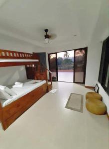 a large bedroom with a bed and a fan at Adama Farmhouse @ Hacienda San Benito in San Celestino
