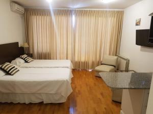 une chambre d'hôtel avec deux lits et une chaise dans l'établissement caseros apart, à Salta