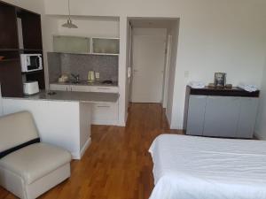 Cet appartement comprend une chambre avec un lit et une cuisine avec un comptoir. dans l'établissement caseros apart, à Salta 5 autres photos