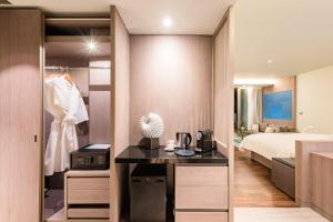 a bedroom with a bed and a desk in a room at Oceanfront Beach Resort - SHA Extra Plus in Patong Beach
