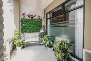 a balcony with plants and a bench at RedDoorz Syariah at Hotel Grand Mentari in Bengkulu