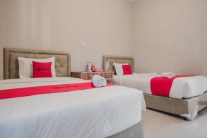 Un pat sau paturi într-o cameră la RedDoorz Syariah at Hotel Grand Mentari