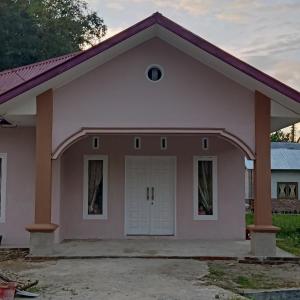 a small pink house with a garage at Zahra Syariah Home Stay in Bukittinggi