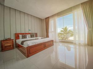 a bedroom with a bed and a large window at Montagne Regency in Kampot