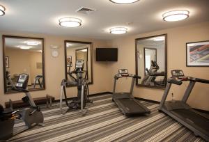 a fitness room with tread machines and mirrors at Candlewood Suites Alexandria, an IHG Hotel in Alexandria