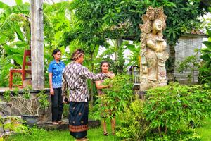 a group of people standing next to a statue at Bali Eco Living Yoga Healing Meditation and Retreat Center in Denpasar