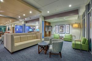a lobby with a couch and chairs and tables at Holiday Inn Express & Suites - Hermiston Downtown by IHG in Hermiston