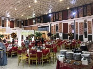 a banquet hall with red tables and chairs at Sinar Sport Hotel in Bengkulu