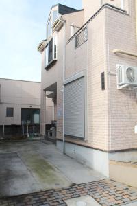 un bâtiment avec une porte de garage sur son côté dans l'établissement 近辺天然温泉5Ldkまるまる貸切日暮里駅まで直通, à Soka