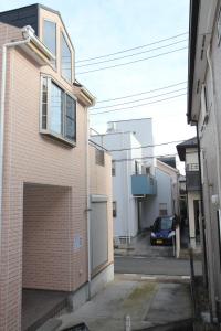 un edificio de ladrillo con garaje en una calle en 近辺天然温泉5Ldkまるまる貸切日暮里駅まで直通, en Soka