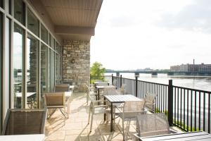 balcón con mesas y sillas y vistas al agua en Holiday Inn Express & Suites Rock Falls, an IHG Hotel, en Rock Falls