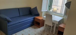 a living room with a blue couch and a table at AFFITTACAMERE ROMANSTYLE in Rome