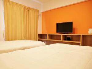 Habitación de hotel con 2 camas y TV de pantalla plana. en Mango Resort Okinawa Naha en Naha