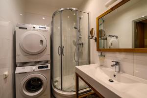 a bathroom with a shower and a washing machine at Liepaja Apartments Downtown in Liepāja +59 photos