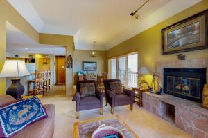 a living room with a fireplace and a couch and chairs at Purgatory Village #305 in Durango Mountain Resort