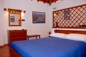 a bedroom with a blue bed and a dresser at Vila Elena 2 astoning view in Steni Vala Alonissos