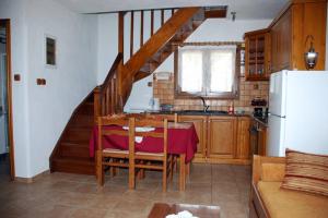 a kitchen with a dining room table and a staircase at Vila Elena 2 astoning view in Steni Vala Alonissos