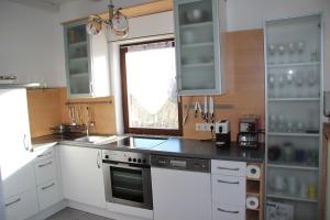 eine Küche mit weißen Schränken, einem Waschbecken und einem Fenster in der Unterkunft Kellerstöckl Eisenberg/Pinka Weiner in Eisenberg an der Pinka