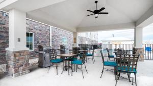 Candlewood Suites Waco, an IHG Hotel في واكو: فناء به طاولات وكراسي ومدفأة