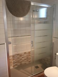 bagno con doccia in vetro e servizi igienici. di Apartamentos Encanto Del Mar a Cala Galdana
