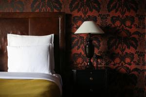 a bedroom with a bed and a lamp on a night stand at Rooms Hotel Tbilisi in Tbilisi City