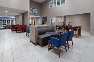图莱里Holiday Inn Express & Suites - Tulare by IHG的一间设有桌椅的等候室和一间餐厅