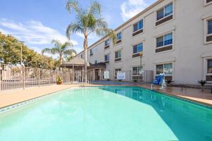 una piscina di fronte a un edificio di Holiday Inn Express & Suites - Tulare, an IHG Hotel a Tulare