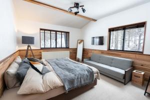 a bedroom with a bed and a couch and windows at Onpoint Madarao in Myoko