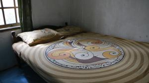 ein großes Bett mit einem Drehmuster darauf in der Unterkunft Sri Homestay in Sermo
