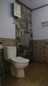ein Bad mit einem WC und einer Duschkabine in der Unterkunft Sri Homestay in Sermo