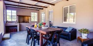 uma sala de estar com uma mesa de madeira e cadeiras em Konings Cottage em Gansbaai