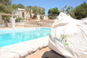 a white bag sitting next to a swimming pool at Contrada Borgin in Marina di Pescoluse