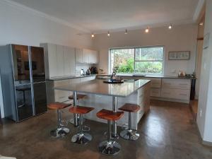 a large kitchen with a large island with bar stools at Lind End Guest Farm in Haenertsburg