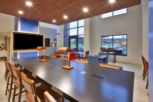 a large table in a room with chairs and a tv at Holiday Inn Express Rochester-Victor, an IHG Hotel in Victor