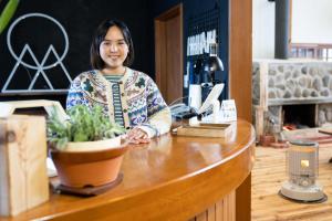 a woman sitting at a counter in a coffee shop at Onpoint Madarao in Myoko