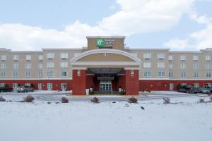 un edificio de hotel con un cartel en la parte delantera en Holiday Inn Express Fort Saskatchewan, an IHG Hotel, en Fort Saskatchewan