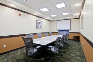 a conference room with a table and chairs and a whiteboard at Wingate by Wyndham Fort Saskatchewan in Fort Saskatchewan +60 photos