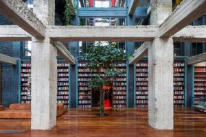 una grande biblioteca con un albero al centro di Stamba Hotel a Tbilisi City