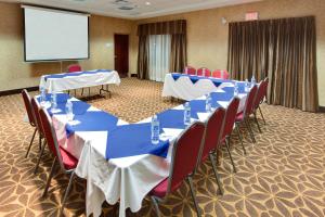 a conference room with tables and chairs and a screen at Holiday Inn Express Hotel & Suites Brockville, an IHG Hotel in Brockville