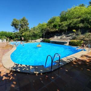 a large blue swimming pool with people in it at La Caseta in Xàtiva